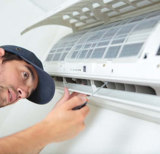 Serwisant z ADK Klimatyzacje Wrocław kończy montaż klimatyzatora ścienno-przysufitowego w mieszkaniu.